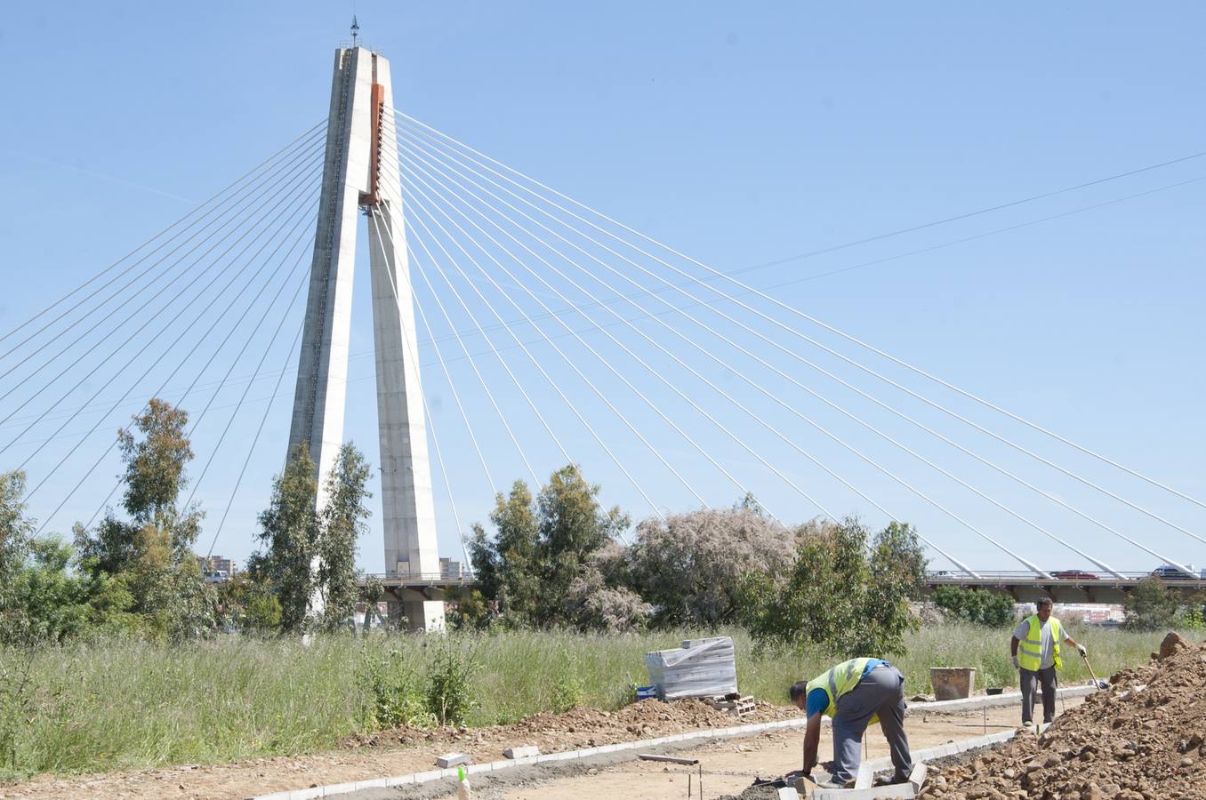 Los operarios trabajando en el nuevo vial que conecta el azud con el paseo fluvial. :: 
