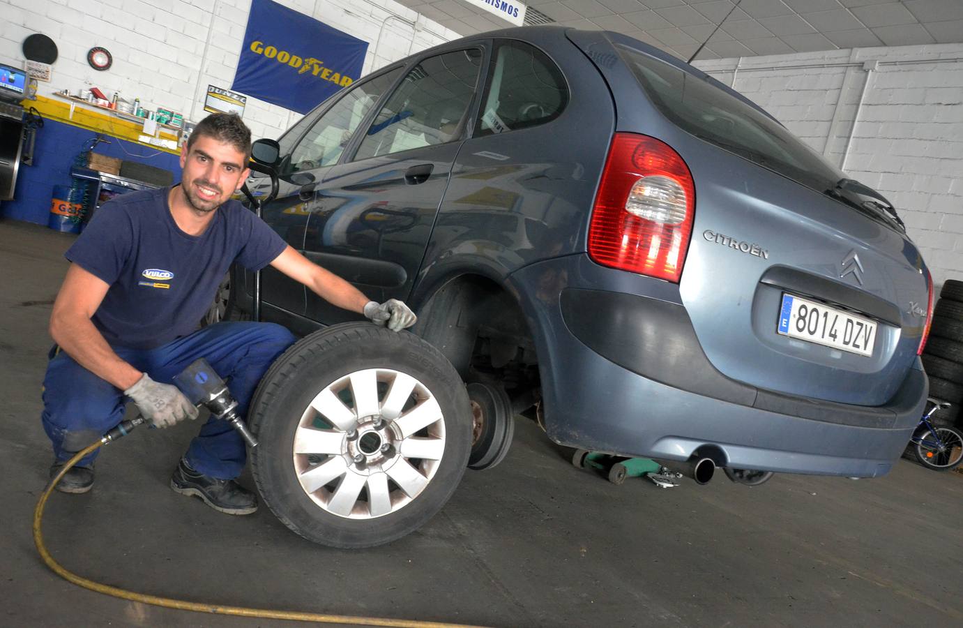 Uva, delantero del CD Badajoz, en plena faena en el taller de neumáticos de su padre. ::
