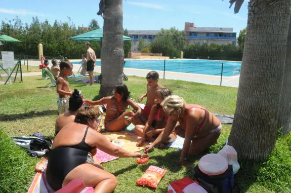 Grupo de emeritenses comiendo en la piscina de Nueva Ciudad, gestionada ahora por Eulen. :: BRÍGIDO