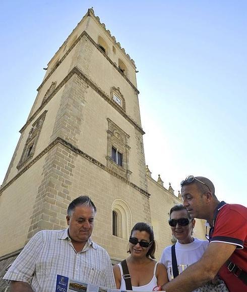 Un grupo de turistas mira un mapa junto a la catedral. 