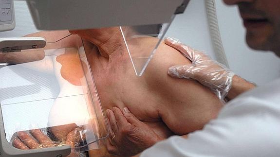 Un técnico especialista en radiodiagnóstico realiza una mamografía a una paciente