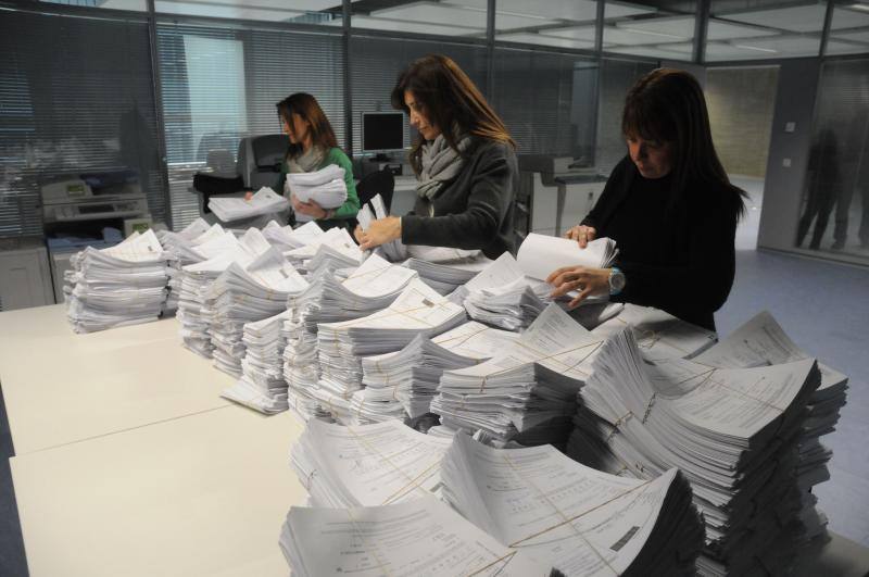 Trabajadoras de la Consejería de Administración Pública junto a algunas de las solicitudes presentadas para presentarse a las oposiciones de la Junta. 