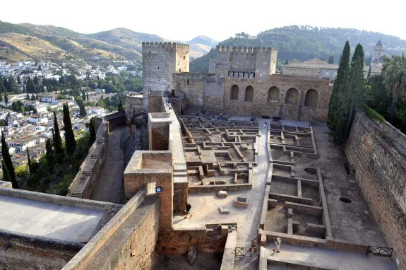 Arriba, una vista de la Alhambra. A la derecha, turistas en el Patio de Machuca. :: efe