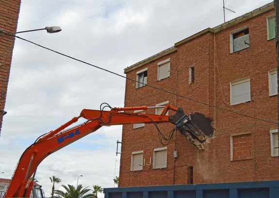 Una máquina, derribando ayer los 'pisos rojos' del barrio de Conquistadores de Villanueva. :: f. h.