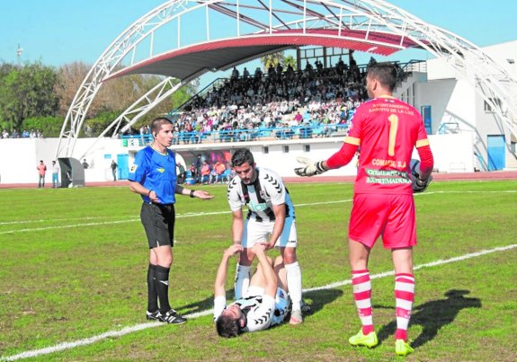 Carreño ayuda a levantarse a Jesús Muñoz ante la mirada de Savu y el árbitro Carretero González. :: pakopí