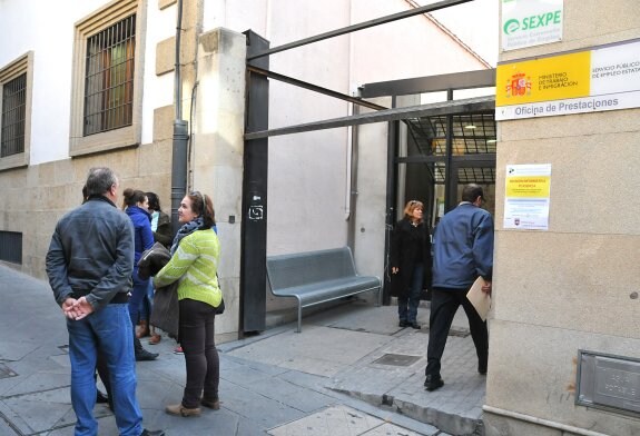 Varias personas charlan a la entrada de la sede del Servicio Extremeño Público de Empleo (Sexpe), en la calle Trujillo :: david palma