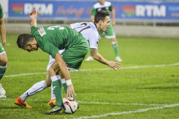 Álex González, del Badajoz, y Pildo, del Díter, pugnan por un balón en el partido del Nuevo Vivero. :: josé vicente arnelas