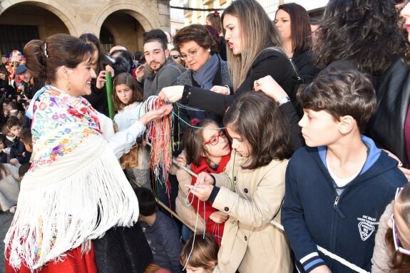 Los Negritos interpretan algunas de sus danzas en la plaza del pueblo mientras los colaboradores en el festejo venden los cordones de San Blas. :: david palma