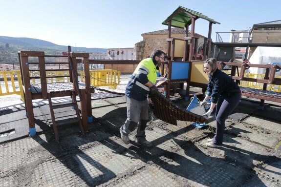 Operarios municipales retiran las losetas de caucho. :: andy solé