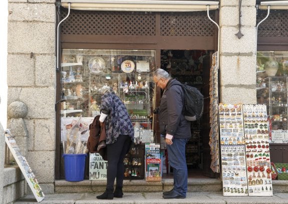 Dos turistas observan los objetos a la venta en la tienda de San Jorge. :: hoy