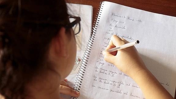 Una niña realiza las tareas escolares que le han mandado sus profesores en su casa. 