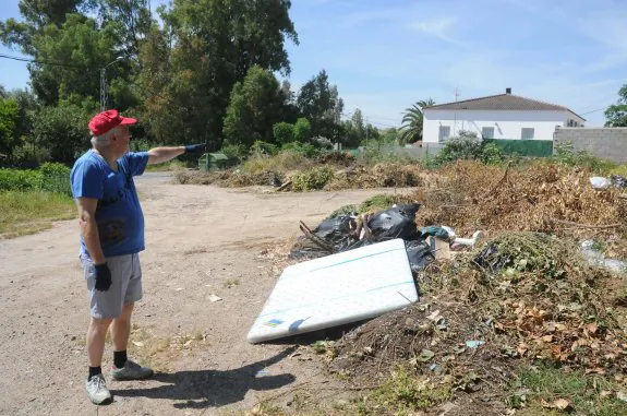 Pedro Merino señala los montones de basura que hay en su solar de Proserpina. :: Brígido