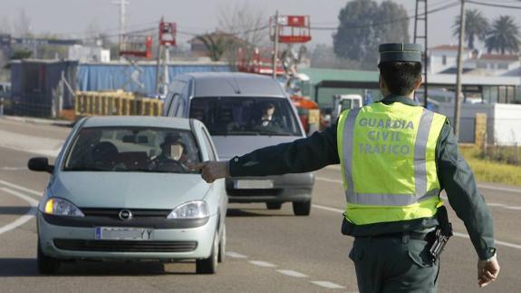 Un agente de la Guardia Civil ordena al conductor de un turismo que gire a la derecha y se detenga.