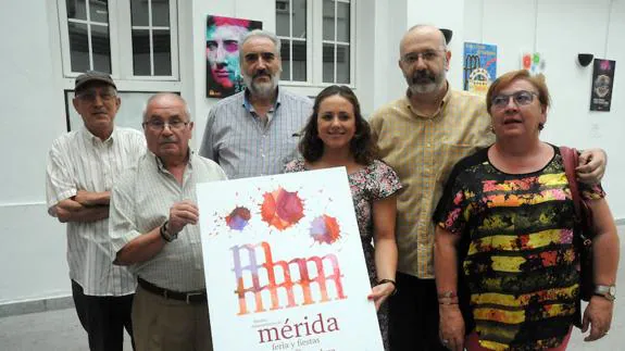 La concejala de Festejos de Mérida posa con el jurado de nuevo para enseñar el nuevo cartel elegido para anunciar la Feria de Septiembre.