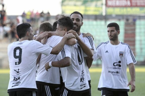 Los jugadores del Mérida abrazan a Hugo Rodríguez tras el empate a dos. :: J. M. ROMERO