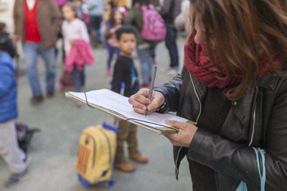 Una madre rellena la encuesta en las inmediaciones del colegio público Prácticas. :: jorge rey