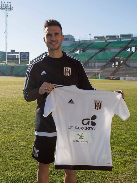 Cascón posa con su nueva camiseta sobre el césped del Romano. :: UD Mérida