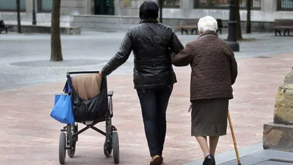 Imagen de archivo de una cuidadora con una mayor dependiente durante un paseo. 