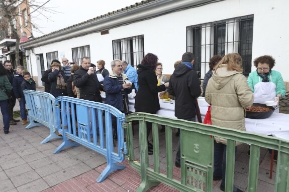 Los participantes en la romería hacen cola para conseguir una ración de prueba con ponche. :: a. méndez