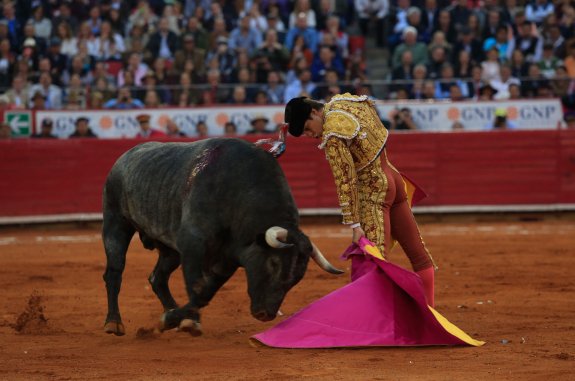 'El Juli' torea al capote a 'Don Marcos' el toro al que cortó las dos orejas el domingo en la México. :: efe