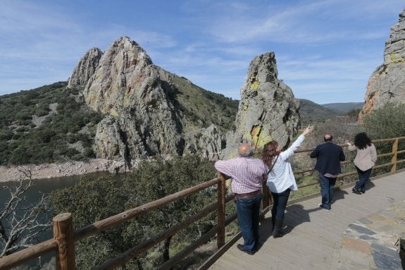 Dos parejas de turistas de Arroyomolinos de Montánchez observan aves junto al Salto del Gitano