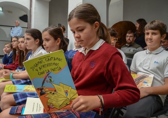 Una niña lee el libro regalado a los alumnos con motivo del Día Internacional del Libro. :: casimiro moreno