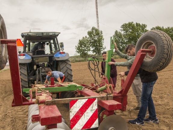 Algunos de los alumnos del Bótoa en el campo de trabajo del instituto con el tractor. :: Pakopí