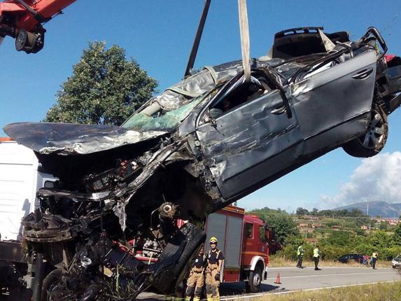 Operarios y bomberos durante las tareas necesarias para cargar el vehículo accidentado en la grúa. :: S.B.