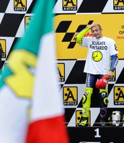 Rossi se prepara en el podio para recibir su trofeo. / AFP