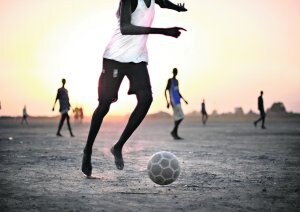 Varios niños juegan descalzos al fútbol  en un descampado de Bentiu, al sur de Sudán.  ::                             ROBERTO SCHMIDT/AFP