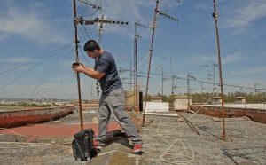 Un antenista trabaja en una azotea de Badajoz estos días. ::                             HOY