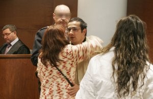 El acusado, Juan Gabriel Carpintero, mira a la cámara mientras la viuda del hombre que asesinó le abraza. ::                             ARMANDO MÉNDEZ