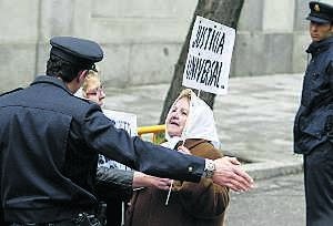 Un agente de Policía discute con una 'Madre de la Plaza de Mayo', ayer, frente al Tribunal Supremo, en Madrid. ::                             AP