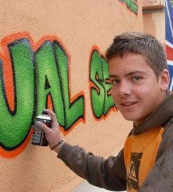 Un joven grafitero pinta varios lienzos en La Isla