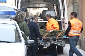 Momento en el que los servicios judiciales sacan del piso de la calle Muñoz Torrero a uno de los fallecidos. ::                             PAKOPÍ