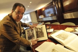 Cecilio Venegas muestra un libro que reproduce una foto antigua de Extremadura. ::                             JOSÉ V. ARNELAS