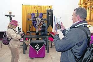 Dos turistas, ayer junto a la talla del Cristo Negro (en la iglesia de la Preciosa Sangre). ::                             MARISA NÚÑEZ