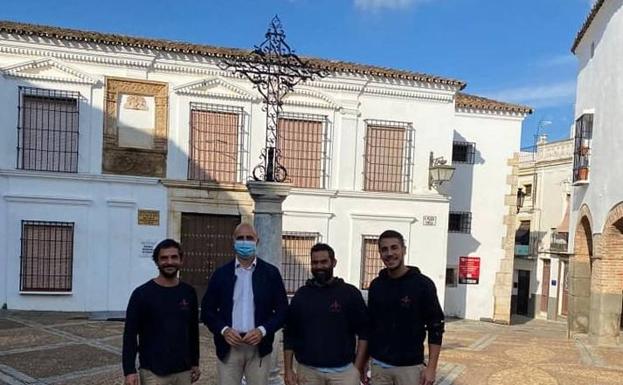 El alcalde junto a los operarios que volvieron a colocar la cruz 