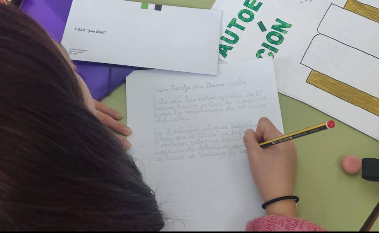 Una de las alumnas escribiendo su carta en clase 