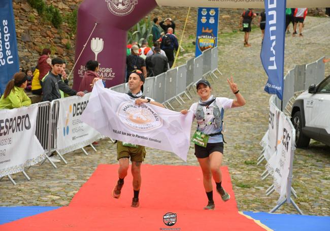 Bárbara y Alejandro en una de las carreras con la bandera de la asociación