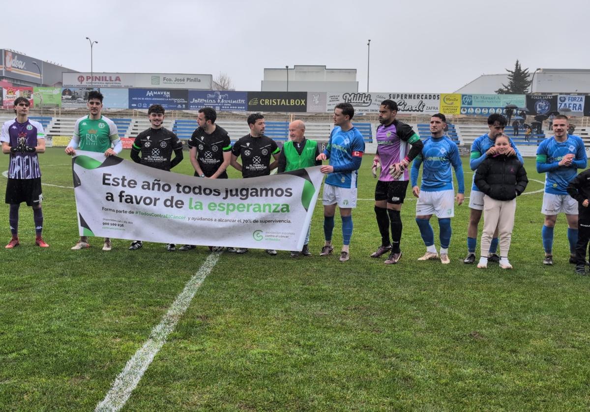 Los jugadores con la pancarta de la AECC antes del partido