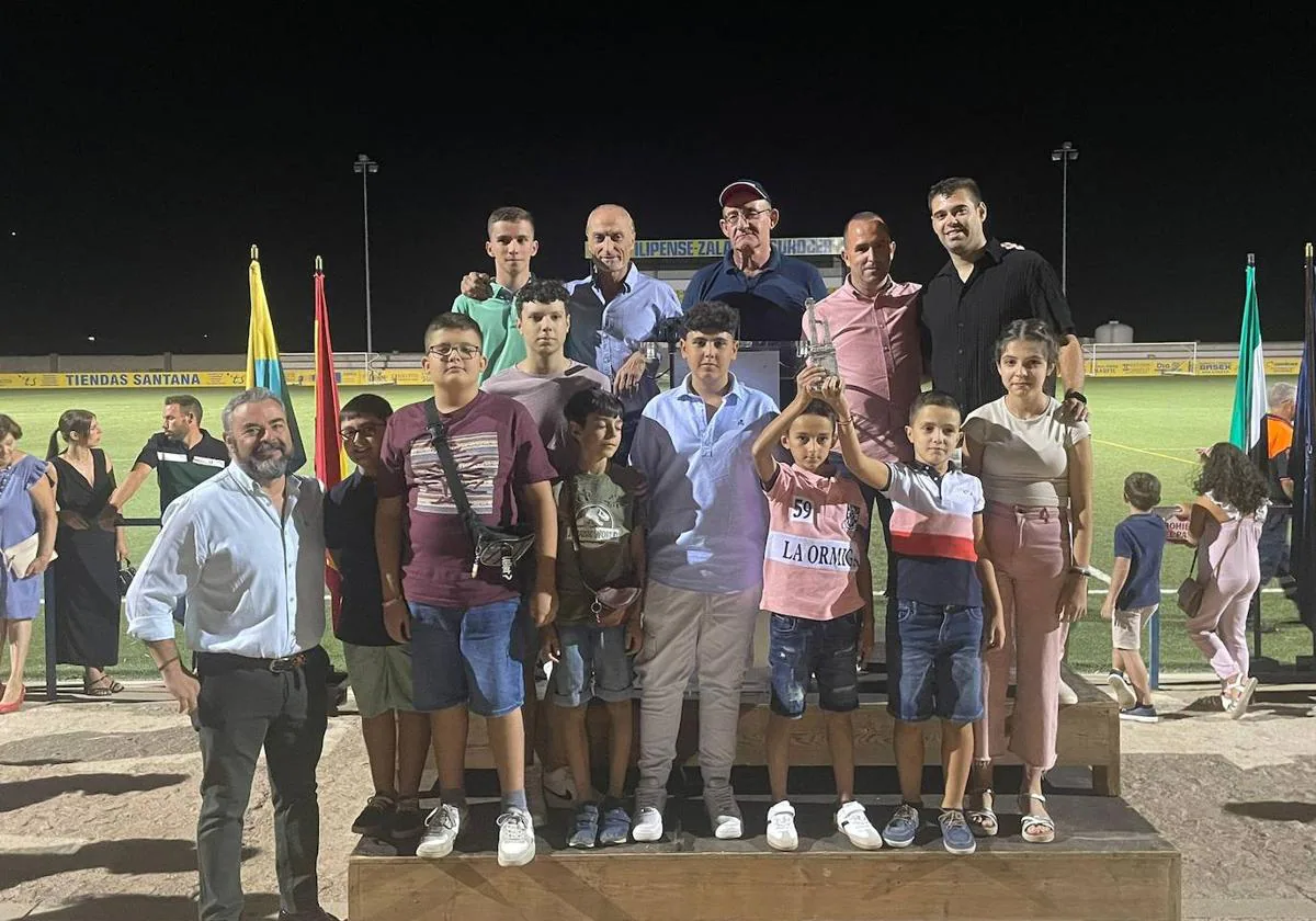 Leonardo Martínez, arriba, segundo por la derecha, junto a los pequeños de la escuela ciclista, el alcalde local y miembros de la corporación.