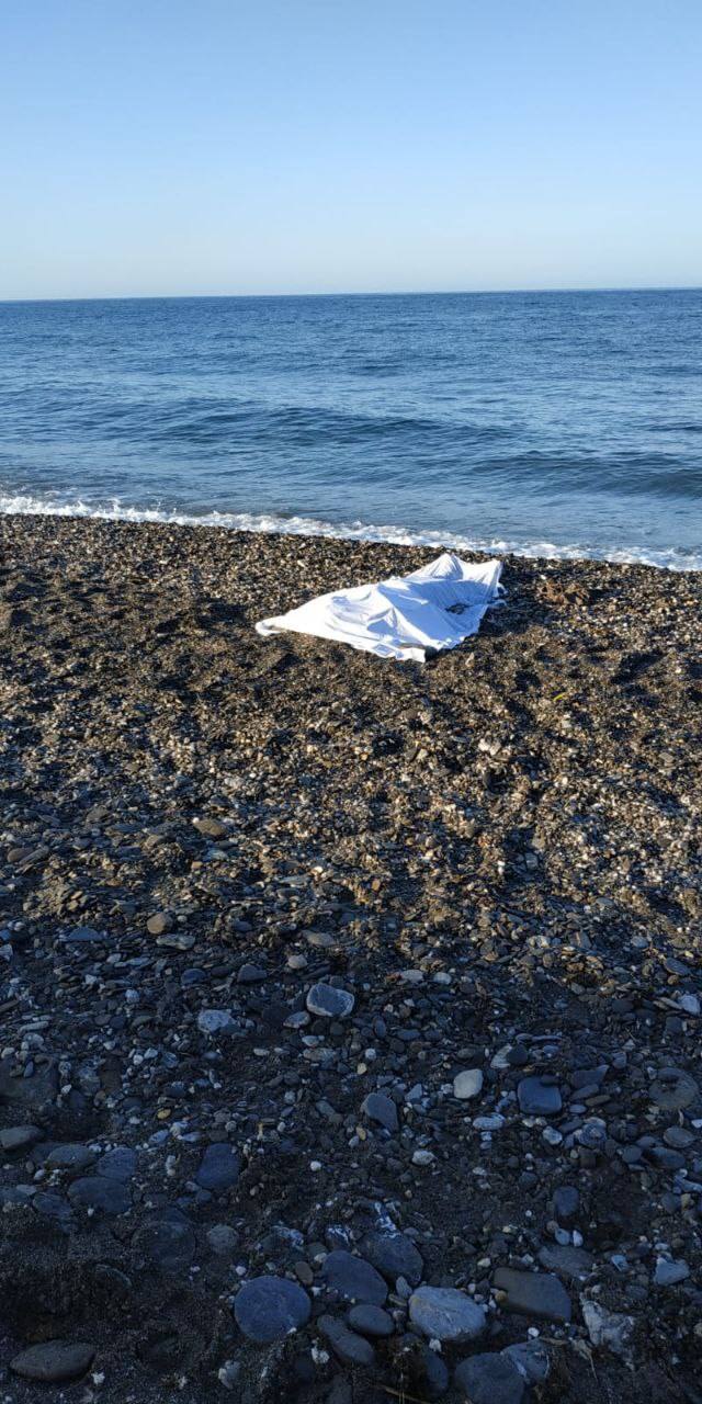Una de las víctimas de Adra, cubierta con una sábana en la orilla del mar.