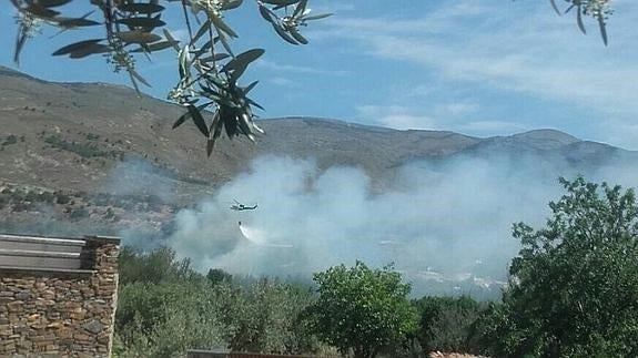 Un avión desacarga sobre la zona del incendio 