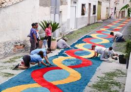 Vecinos de Tíjola preparan las vivas alfombras elaboradas con serrín teñido con colores.