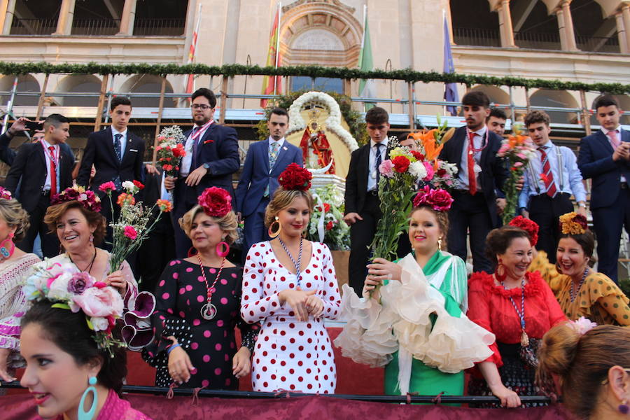 Mujeres ataviadas de gitana y jóvenes voluntarios de la Cofradía Matriz ayudan a los devotos a depositar lo ramos en el panel de Plaza de España :: 