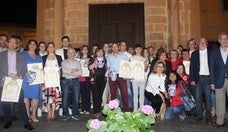 Las personas y organismos premiados en la foto de familia en la remodelaa fachada principal del Palacio de los Niños de Don Gome. 
