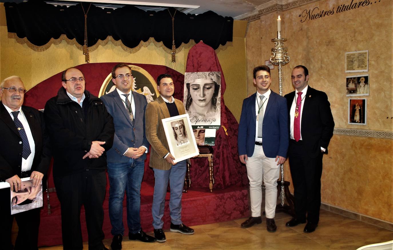 Salva Marcos, con una réplica de su cartel, junto con responsables de la Hermandad, el presidente de la Agrupación de Cofradías, Alfonso Soto, y el arcipreste, Pedro Montesinos. 