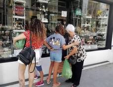 Una familia observa detenidamente un escaparate de la calle Doctor Montoro. 