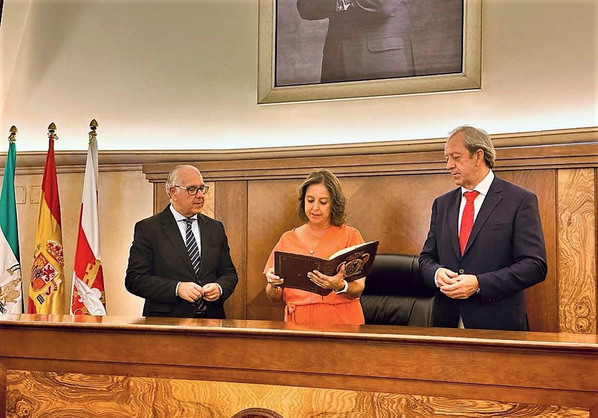 La consejera junto a Jesús Estrella y Paco Carmona tras firmar en el libro de honor.